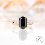 Front view of emerald cut black green moissanite solitaire engagement ring