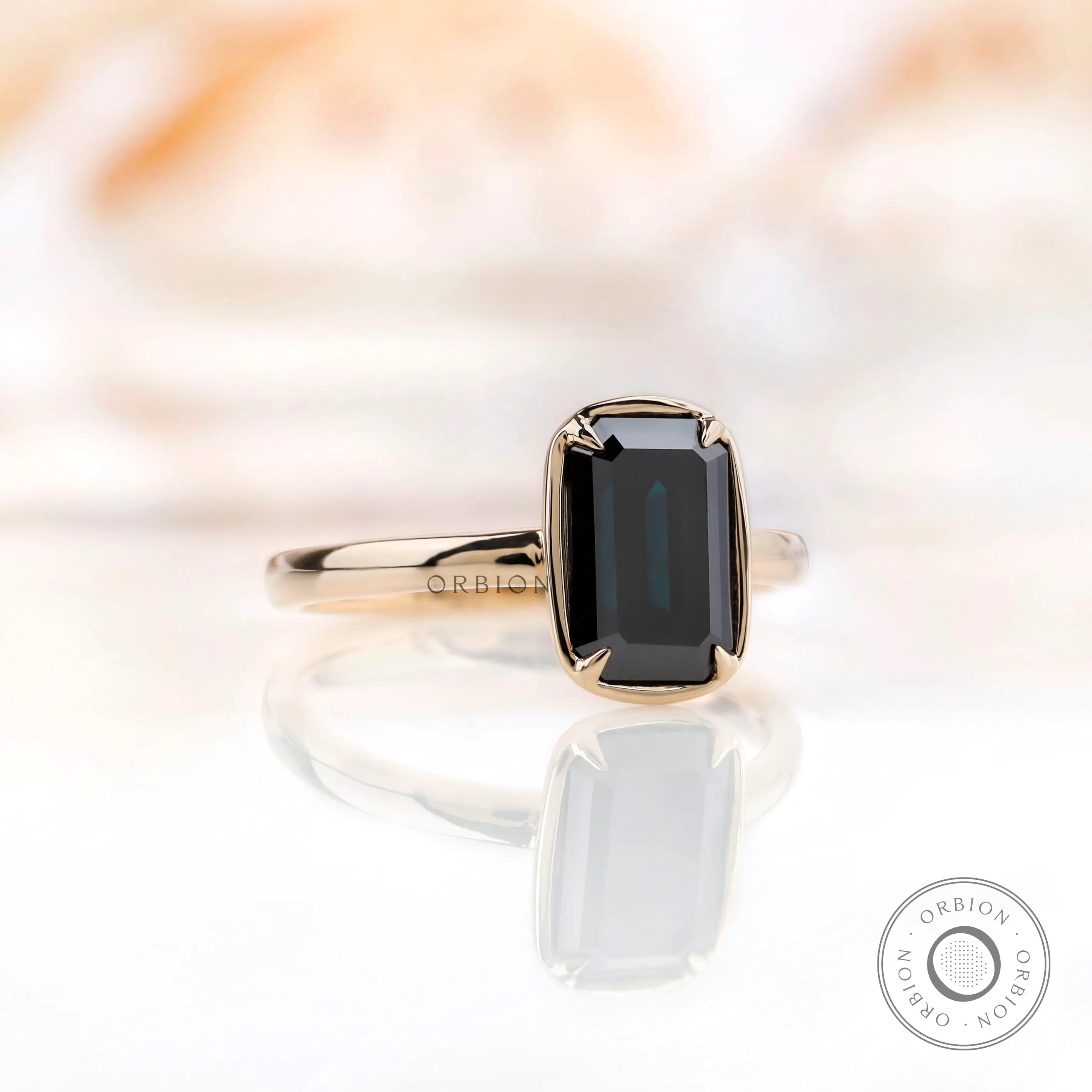 Close-up view of solitaire emerald cut black green moissanite in yellow gold