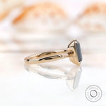 Side view of emerald cut black green moissanite ring in yellow gold