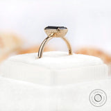 Top-down view of emerald cut black green moissanite engagement ring
