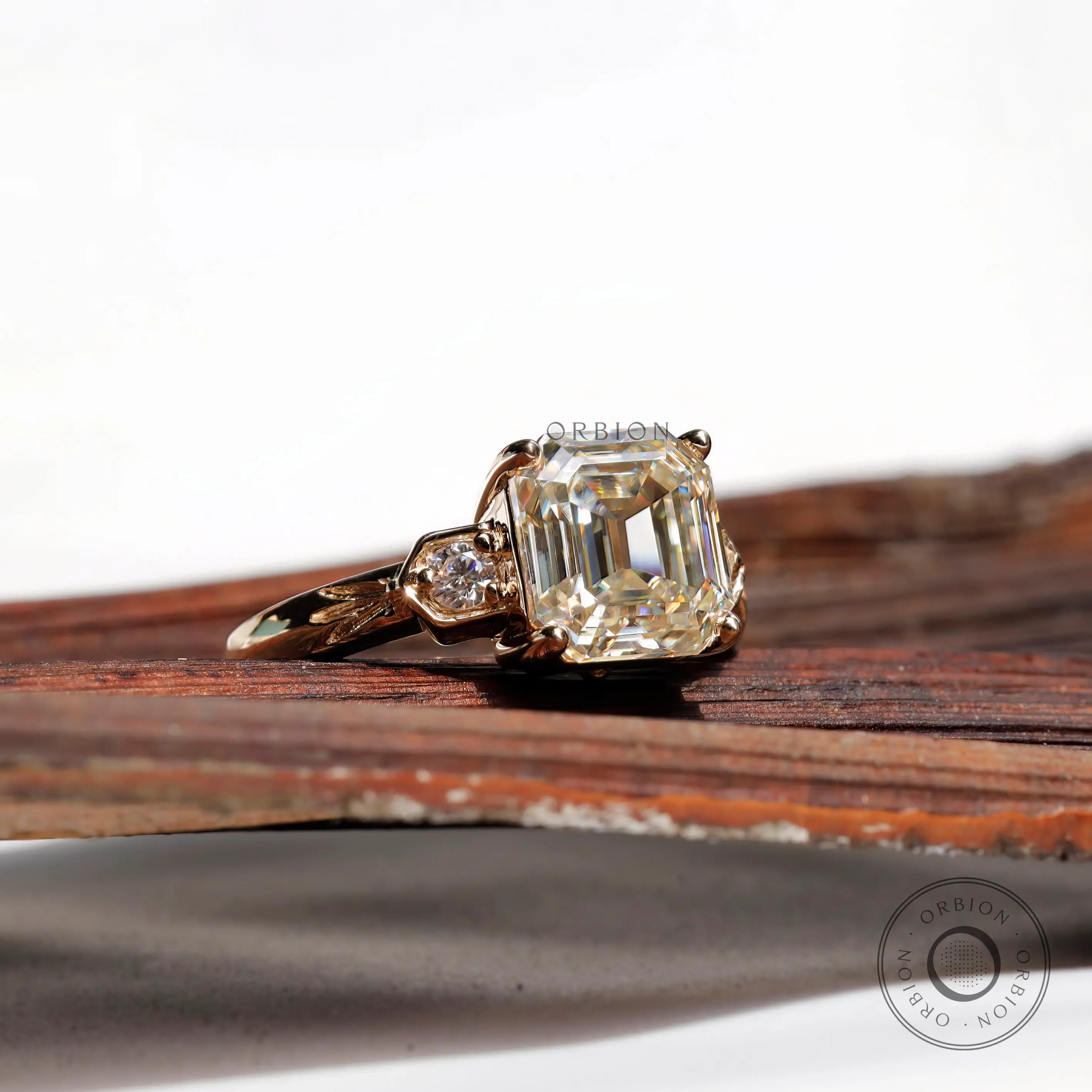 Another angle of the Asscher cut center stone Moissanite engagement ring with round Moissanite side stones, set in 10K yellow gold.