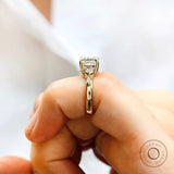 Close-up of the Asscher cut Moissanite center stone ring with two round side stones in 10K yellow gold.