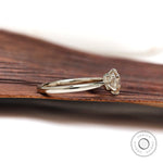 Side profile of elongated round diamond solitaire ring in un-plated white gold