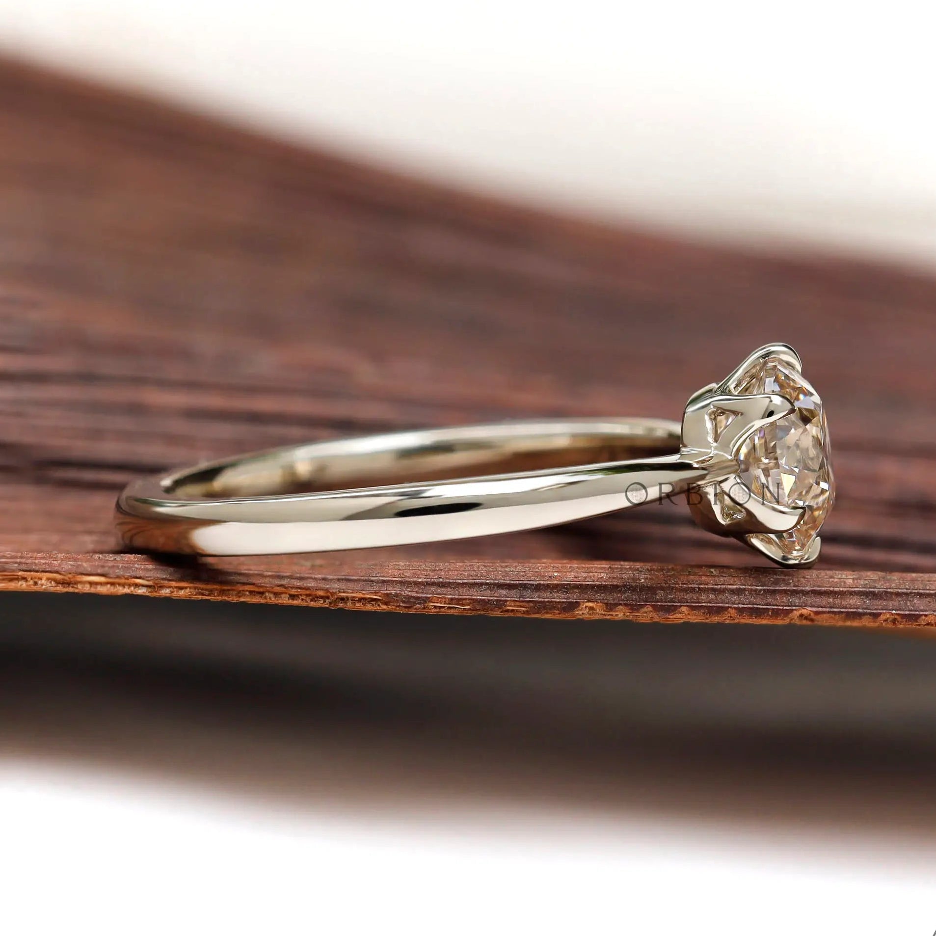 Side profile of elongated round diamond solitaire ring in un-plated white gold