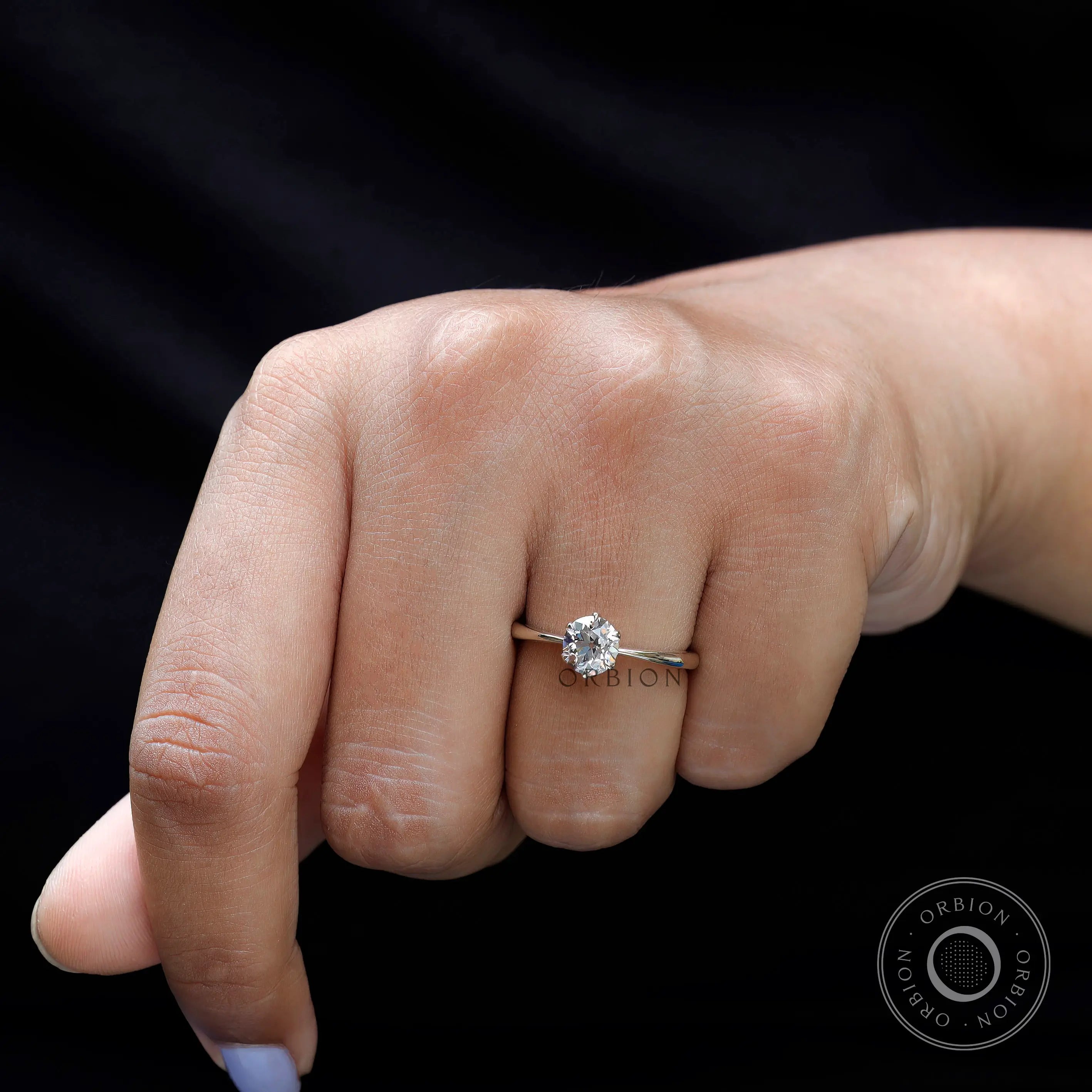 Solitaire diamond ring worn on hand angled view