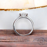 Side profile of oval half bezel set moissanite cathedral ring white gold