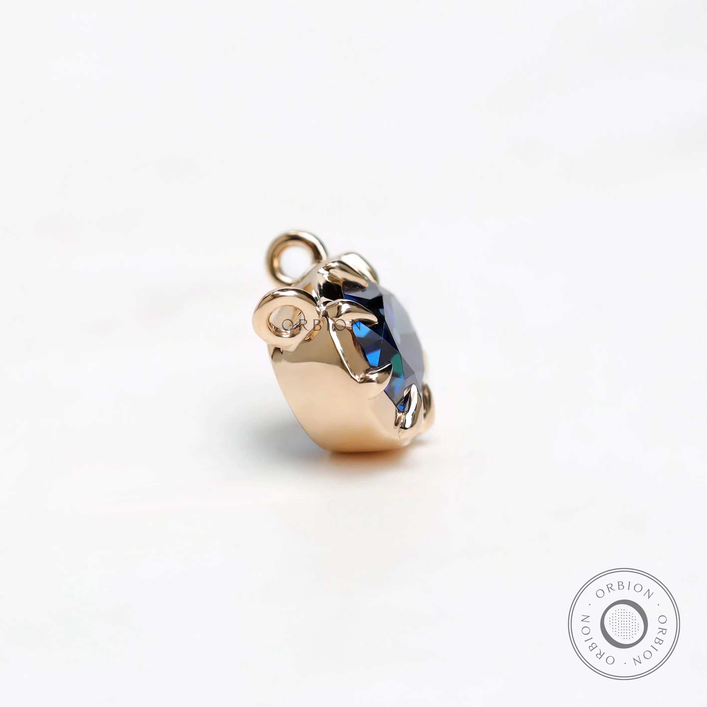 Double loop yellow gold pendant with oval blue stone