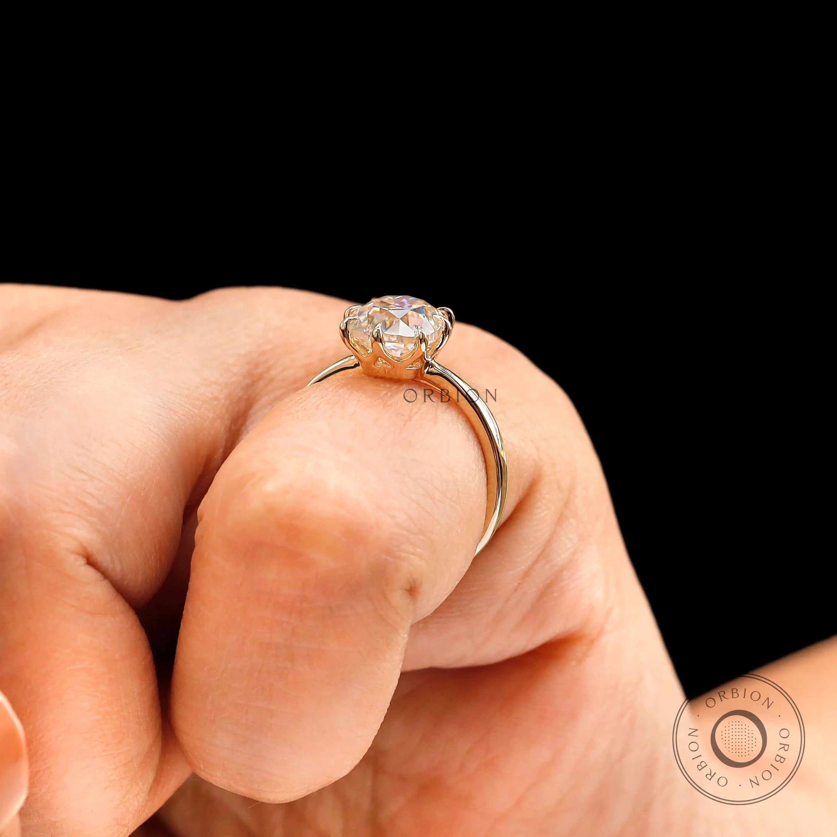 Close up on finger of elongated cushion old mine cut solitaire ring in yellow gold