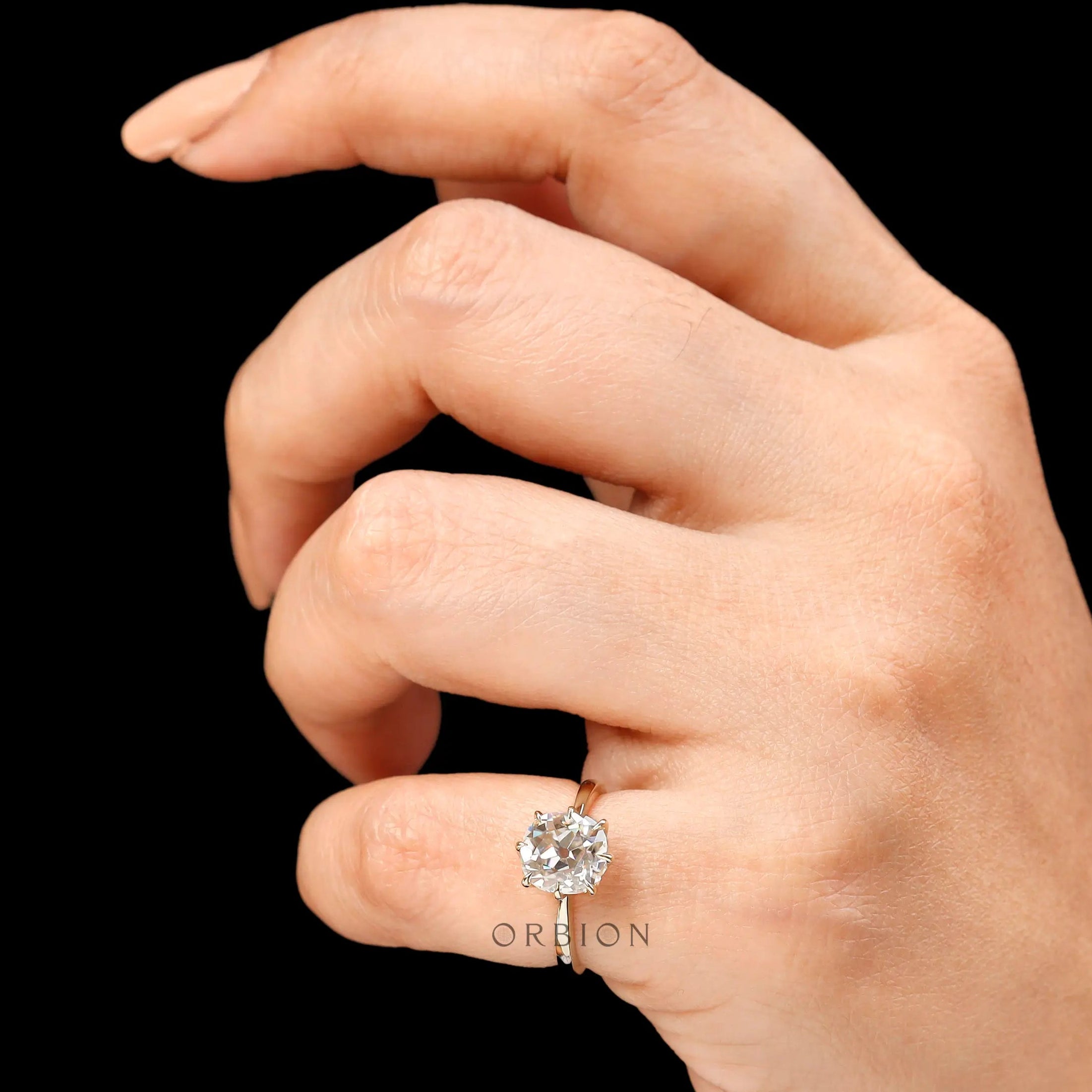 Prong setting detail of elongated cushion old mine cut solitaire ring in 14k yellow gold