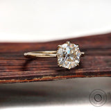 Side profile of elongated cushion old mine cut moissanite ring in polished 14k yellow gold