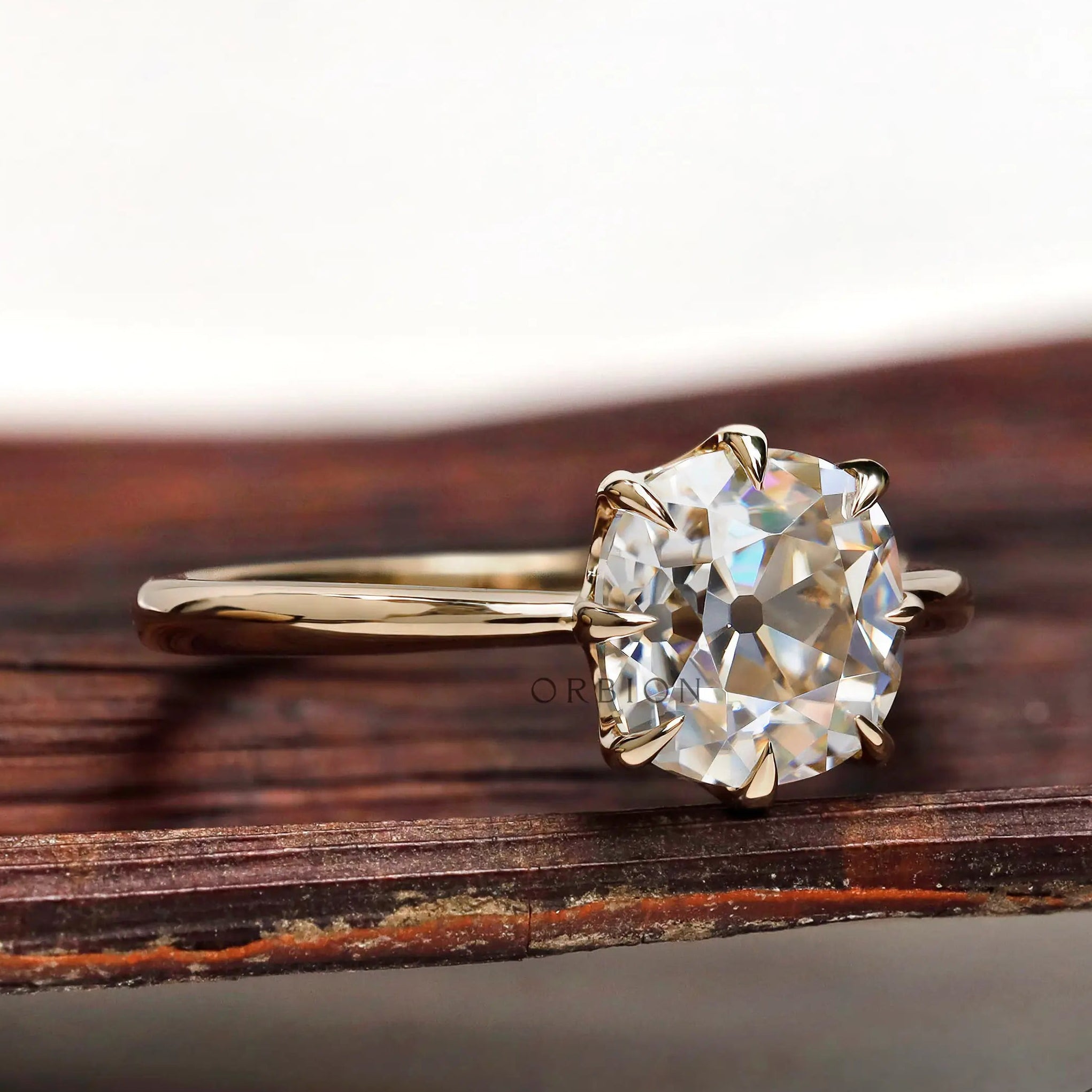 Side profile of elongated cushion old mine cut moissanite ring in polished 14k yellow gold
