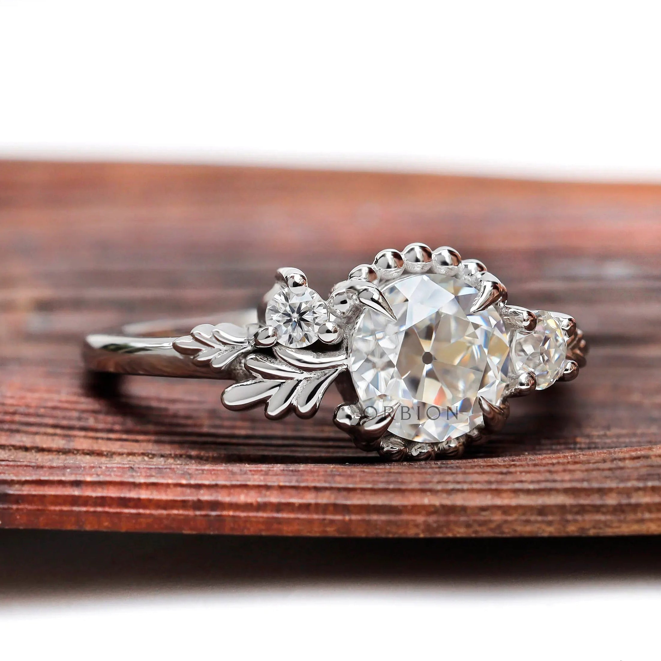 Art nouveau three stone engagement ring with round moissanite