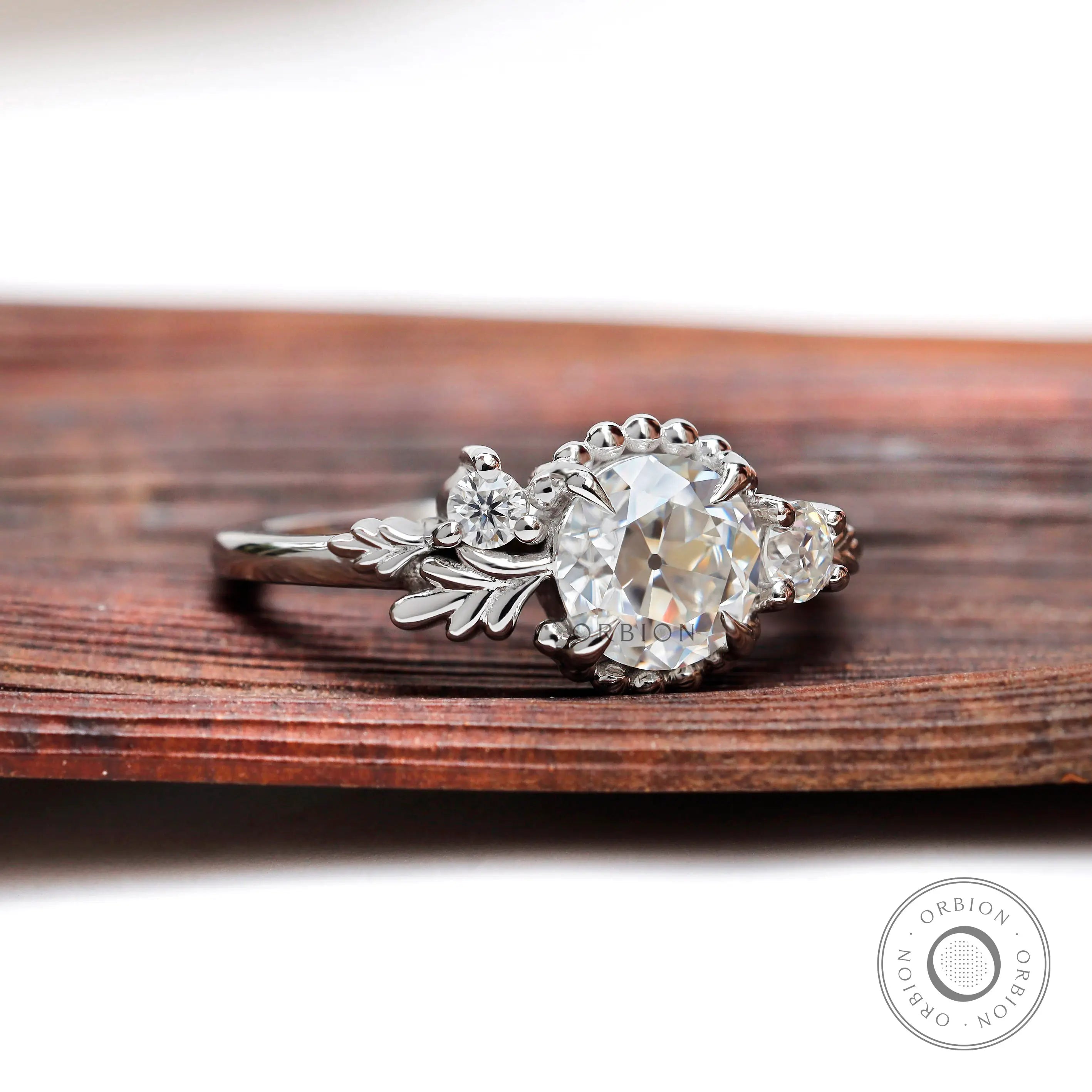 Art nouveau three stone engagement ring with round moissanite