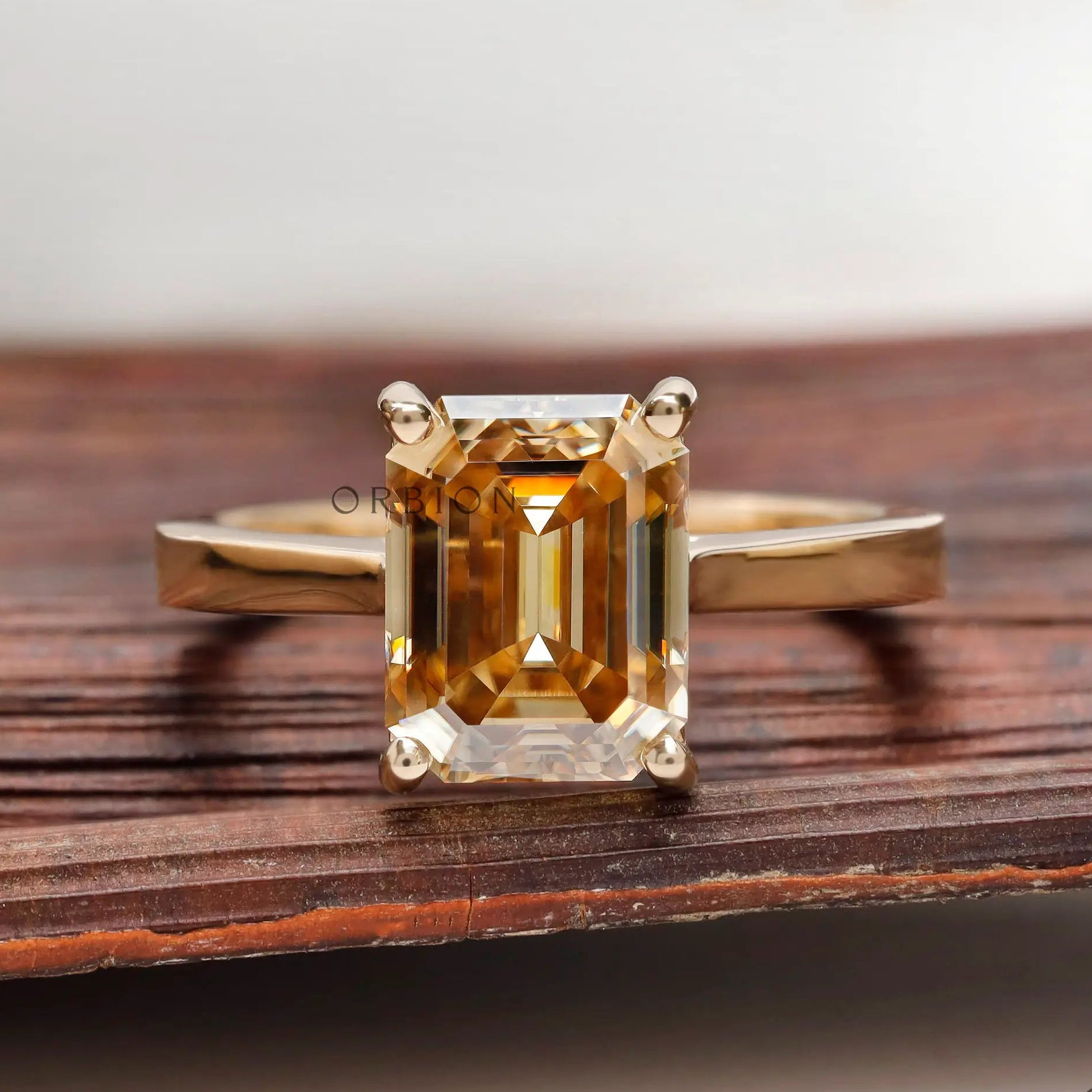 Emerald cut dark champagne moissanite solitaire ring yellow gold