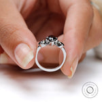 Black moissanite trilogy engagement ring in hand lifestyle image
