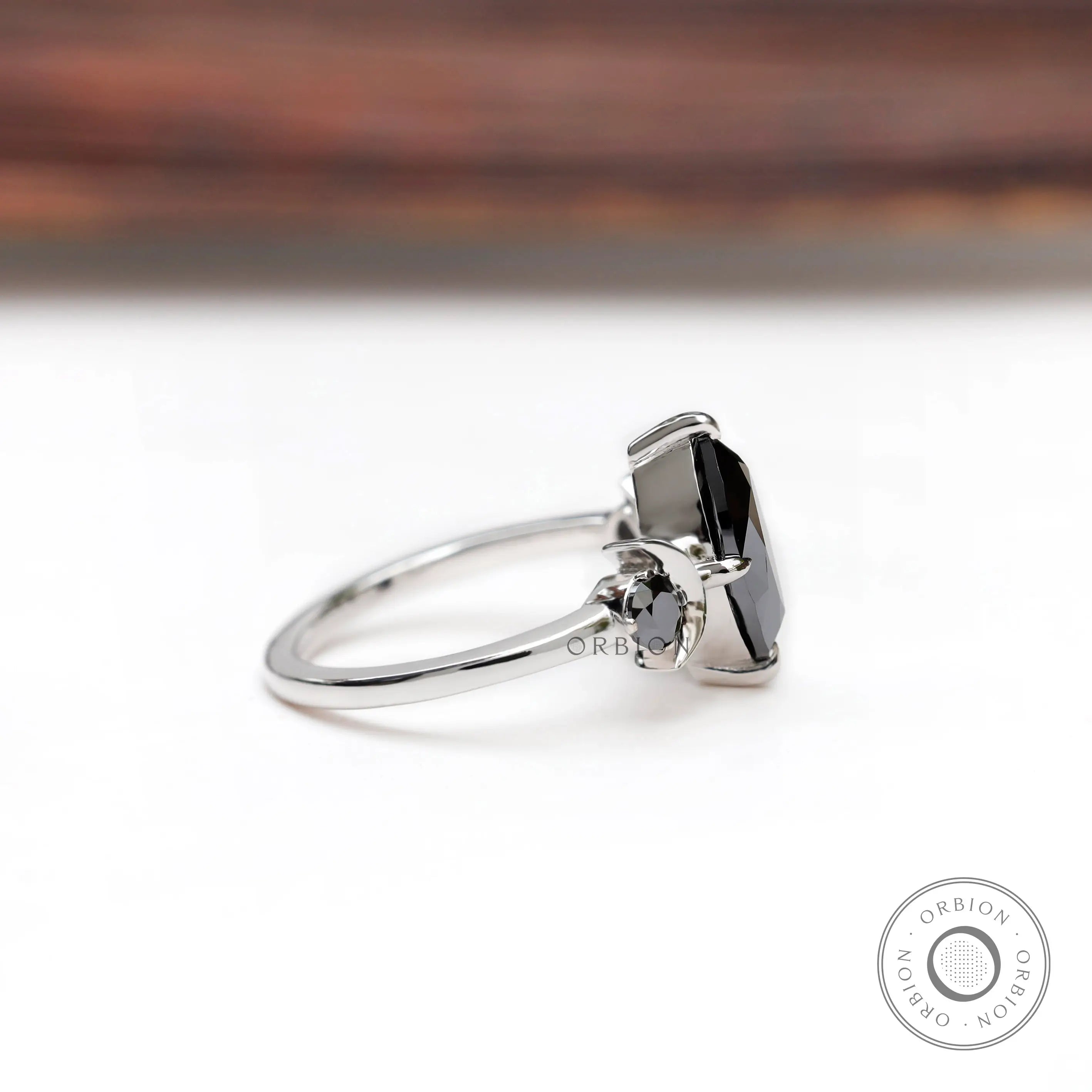 White gold black 3 stone engagement ring angled view