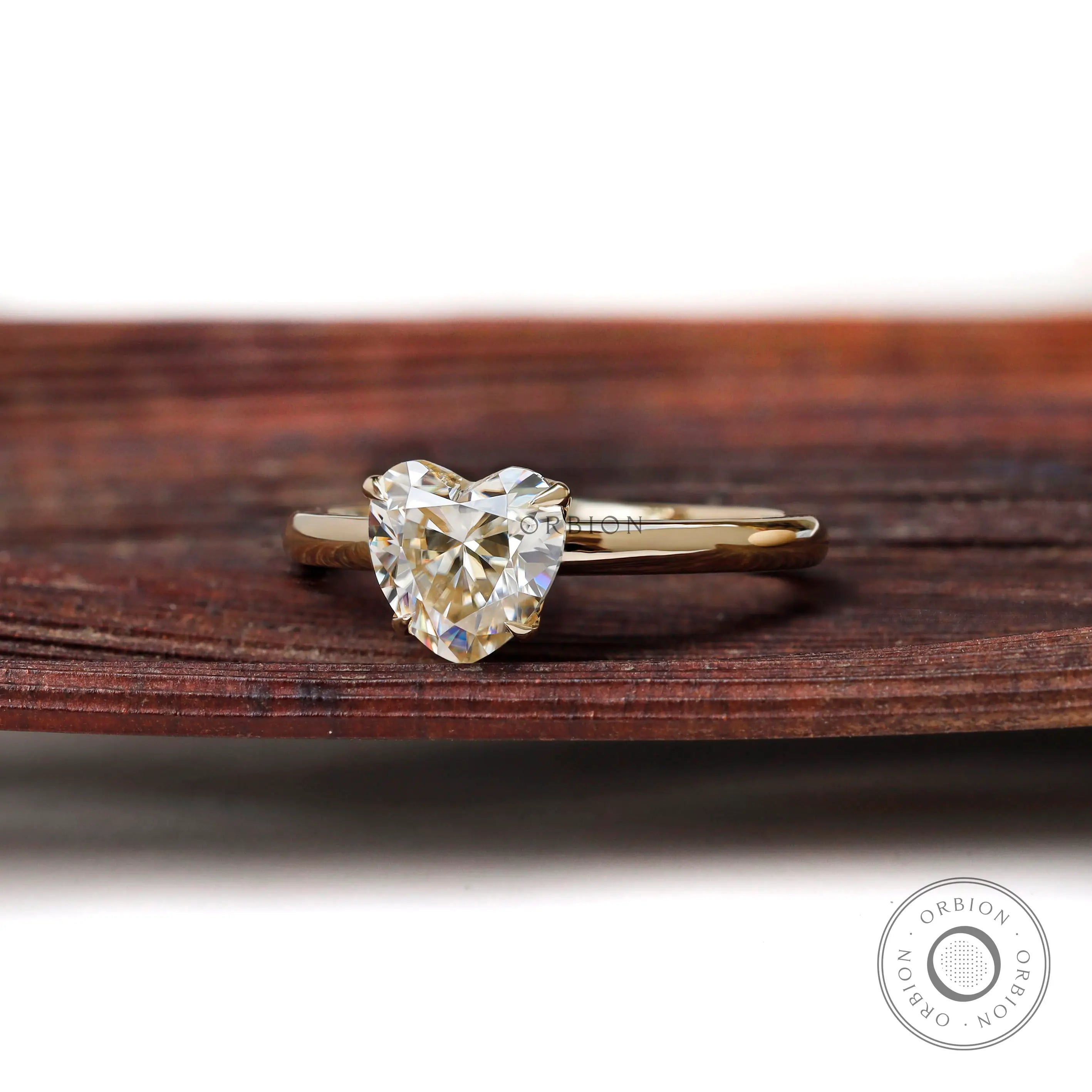 Angled front view heart solitaire ring on textured wooden surface