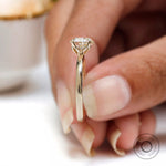 Tulip prong side profile detail of heart shaped solitaire ring held between fingers