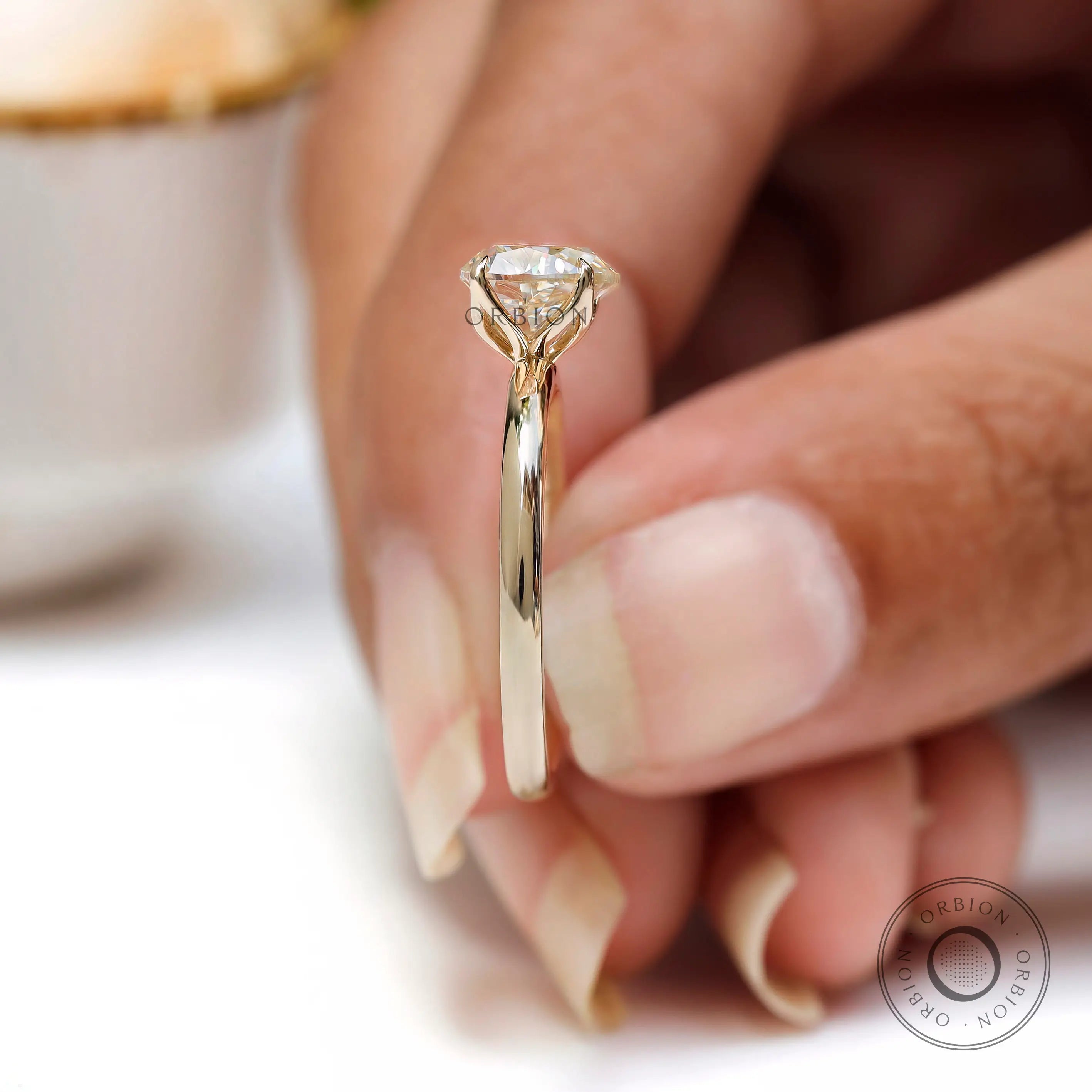 Tulip prong side profile detail of heart shaped solitaire ring held between fingers