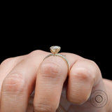 Side profile heart solitaire ring worn on hand with black background