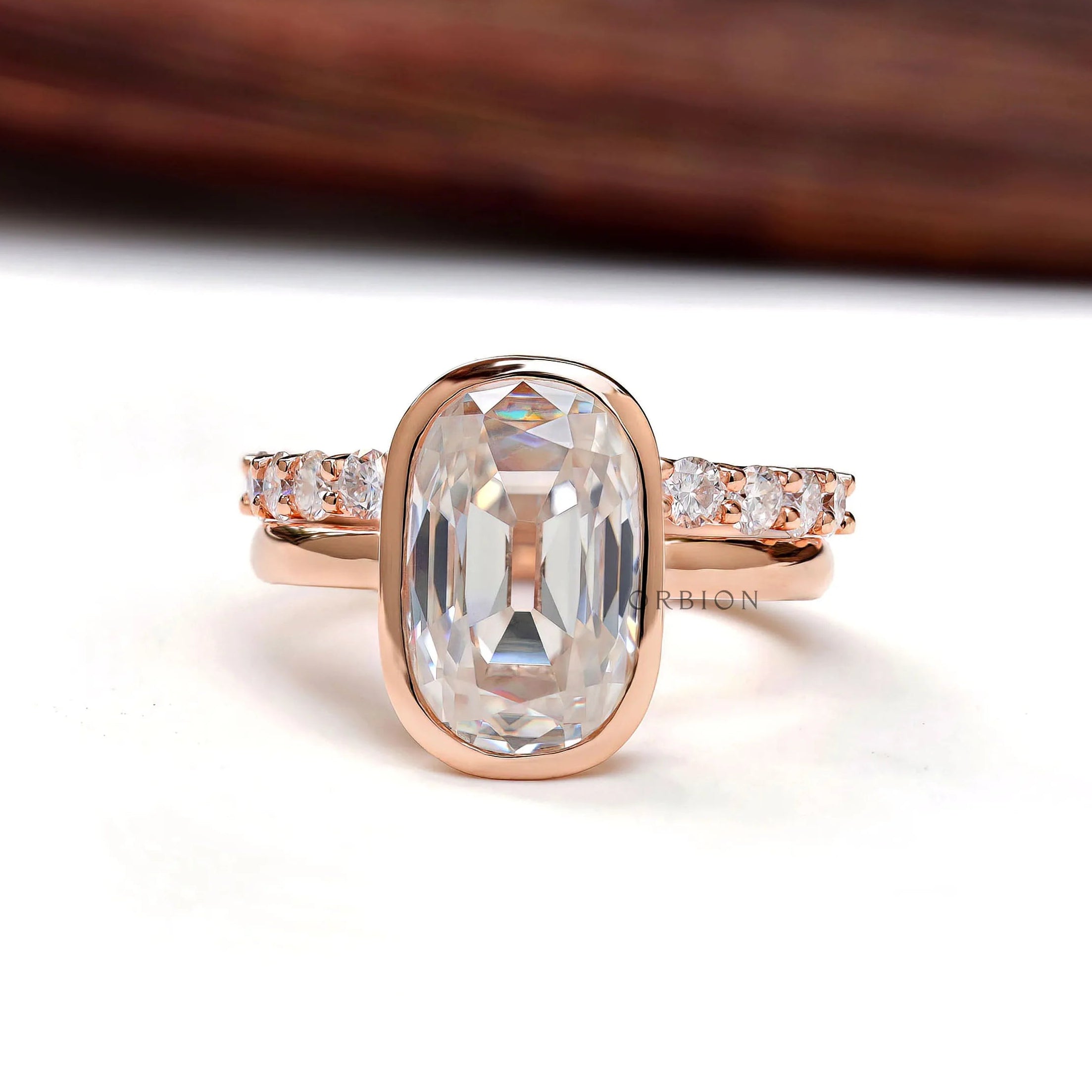 Elongated cushion Old Mine Cut moissanite bezel ring in rose gold front view