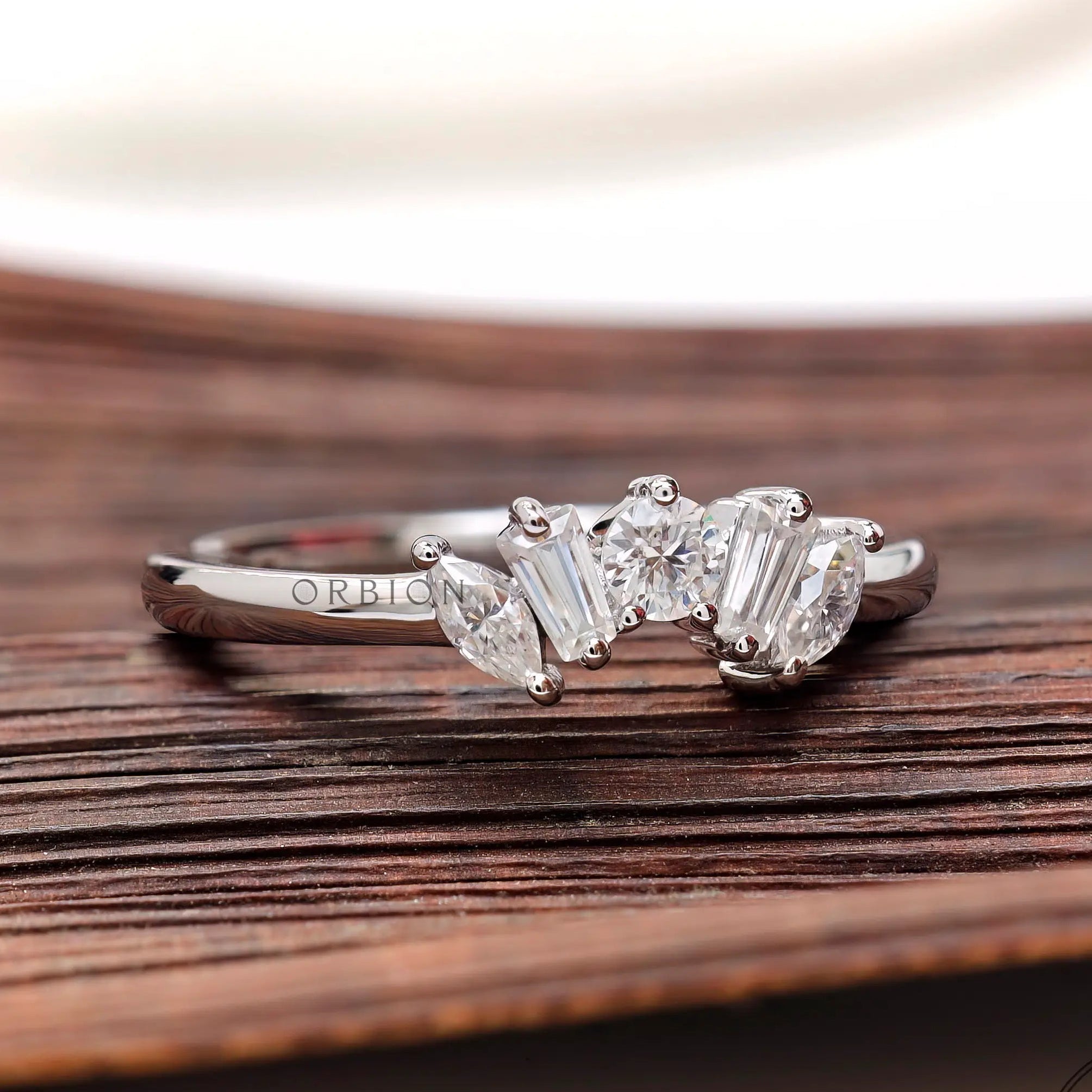 Angled view of mixed shape moissanite curve