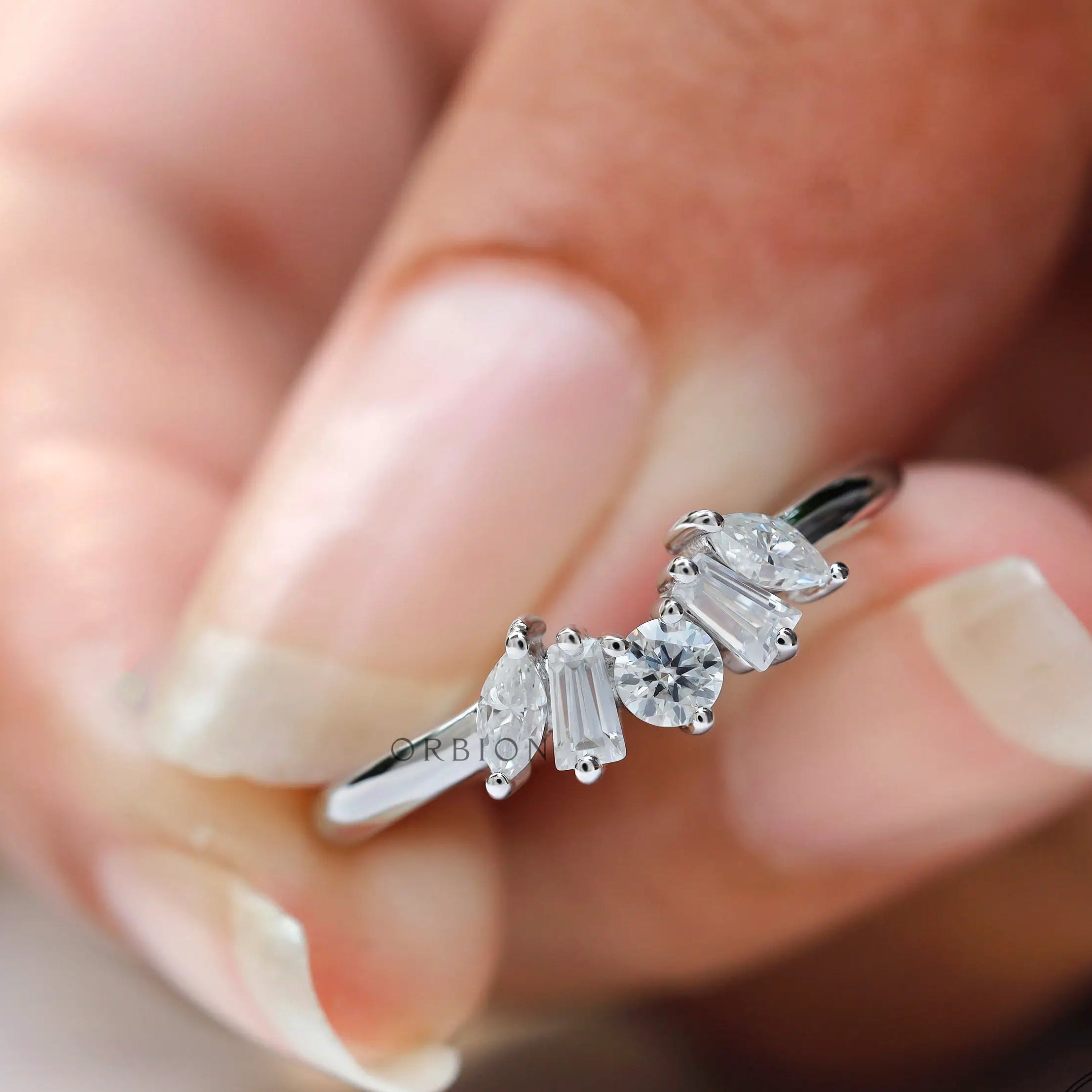 Close-up of multi stones moissanite with glossy white gold band finish