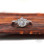 Front view three stone Old European cut ring on wood
