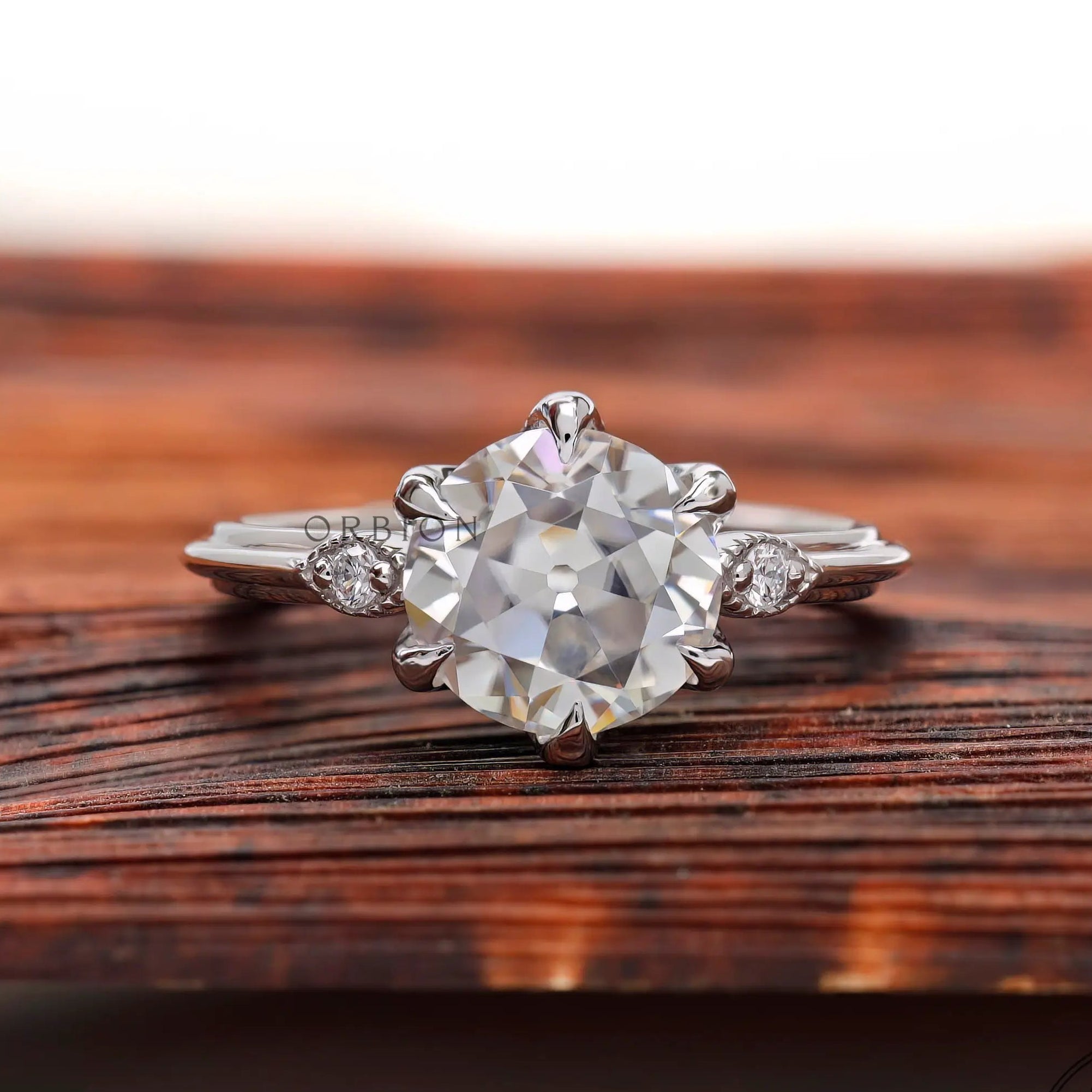 Front view three stone Old European cut ring on wood