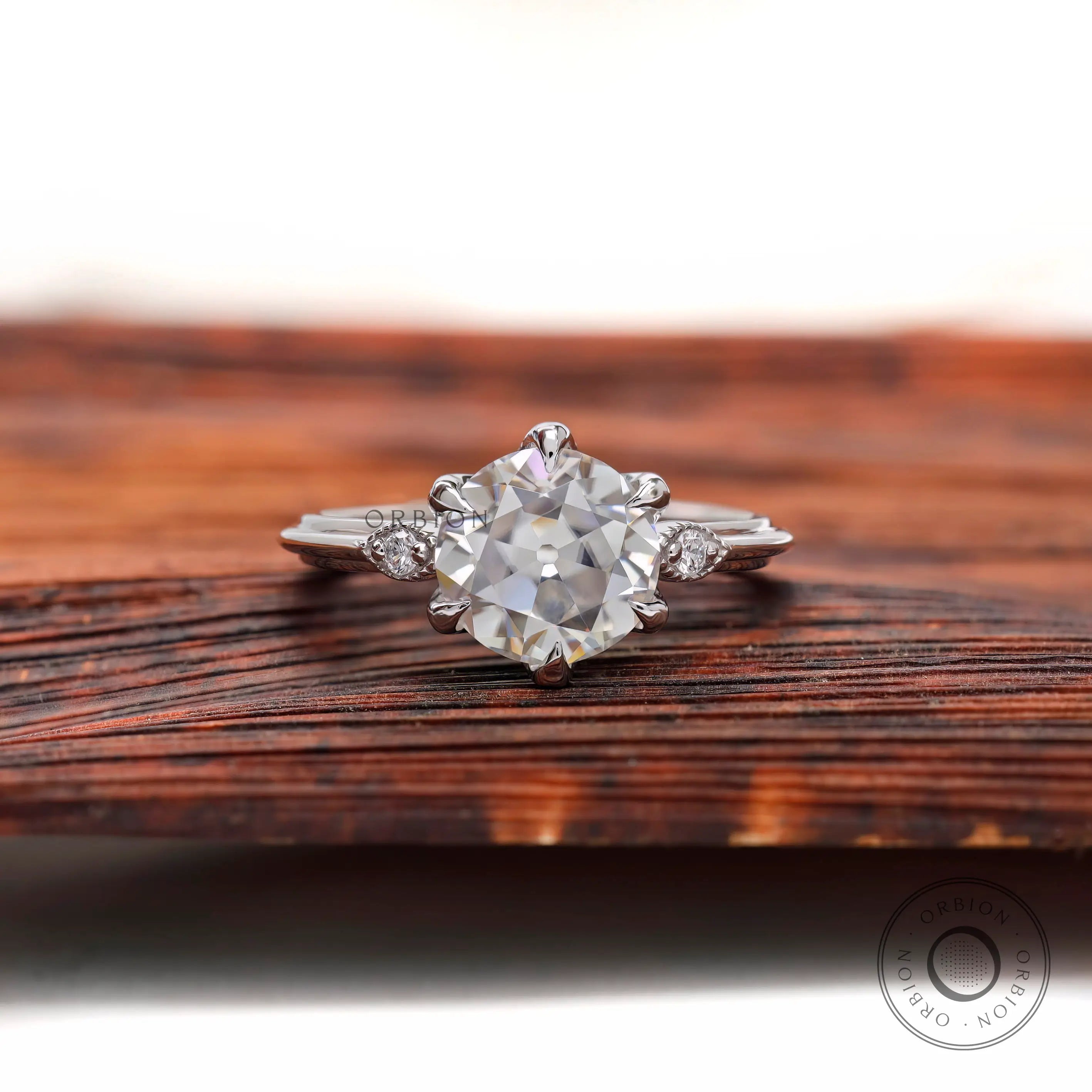 Front view three stone Old European cut ring on wood