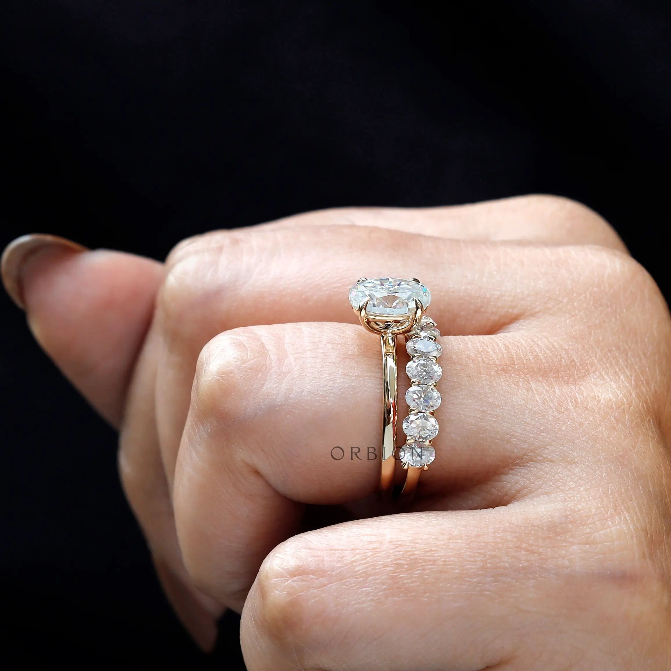 Side profile showing oval solitaire and oval stone band
