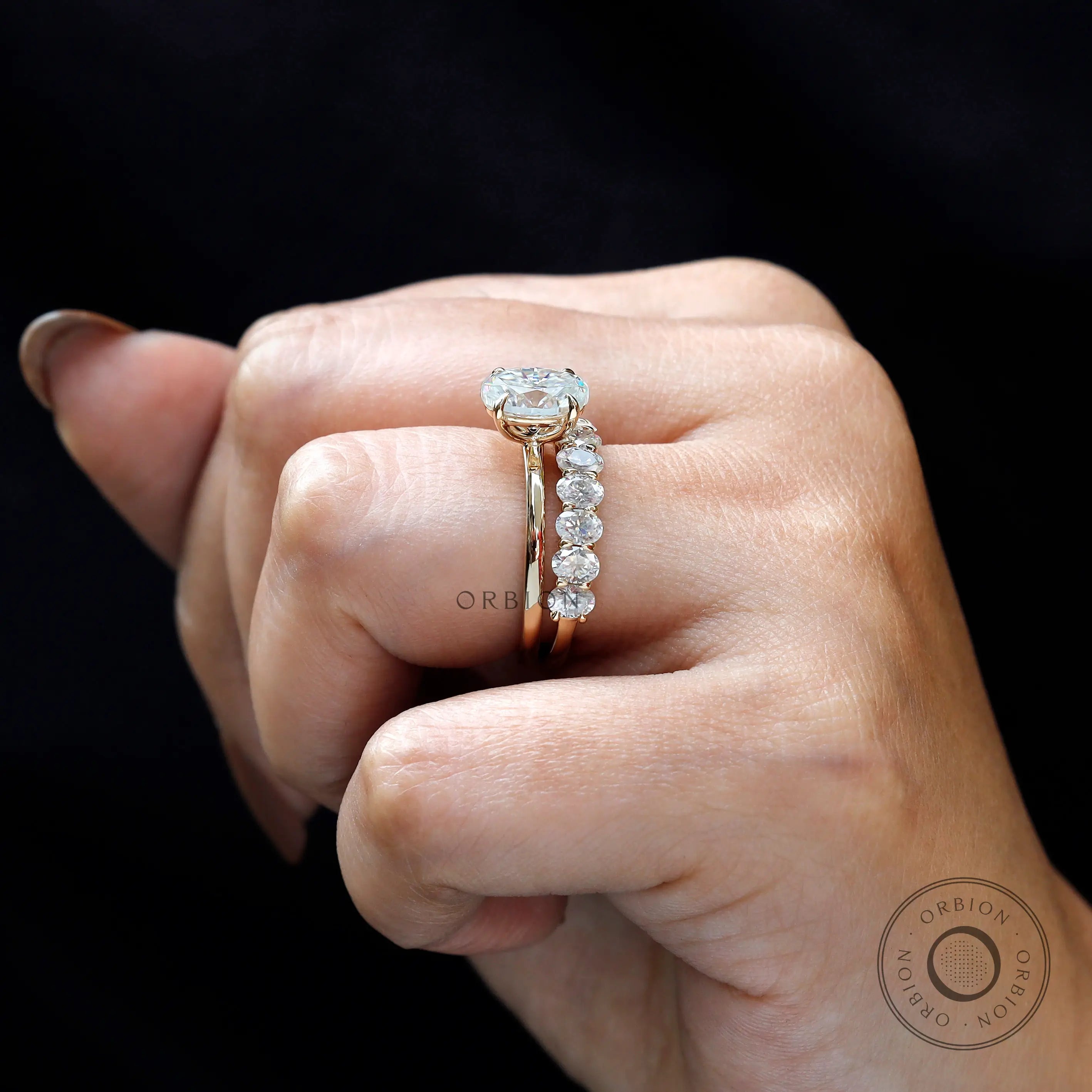 Side profile showing oval solitaire and oval stone band