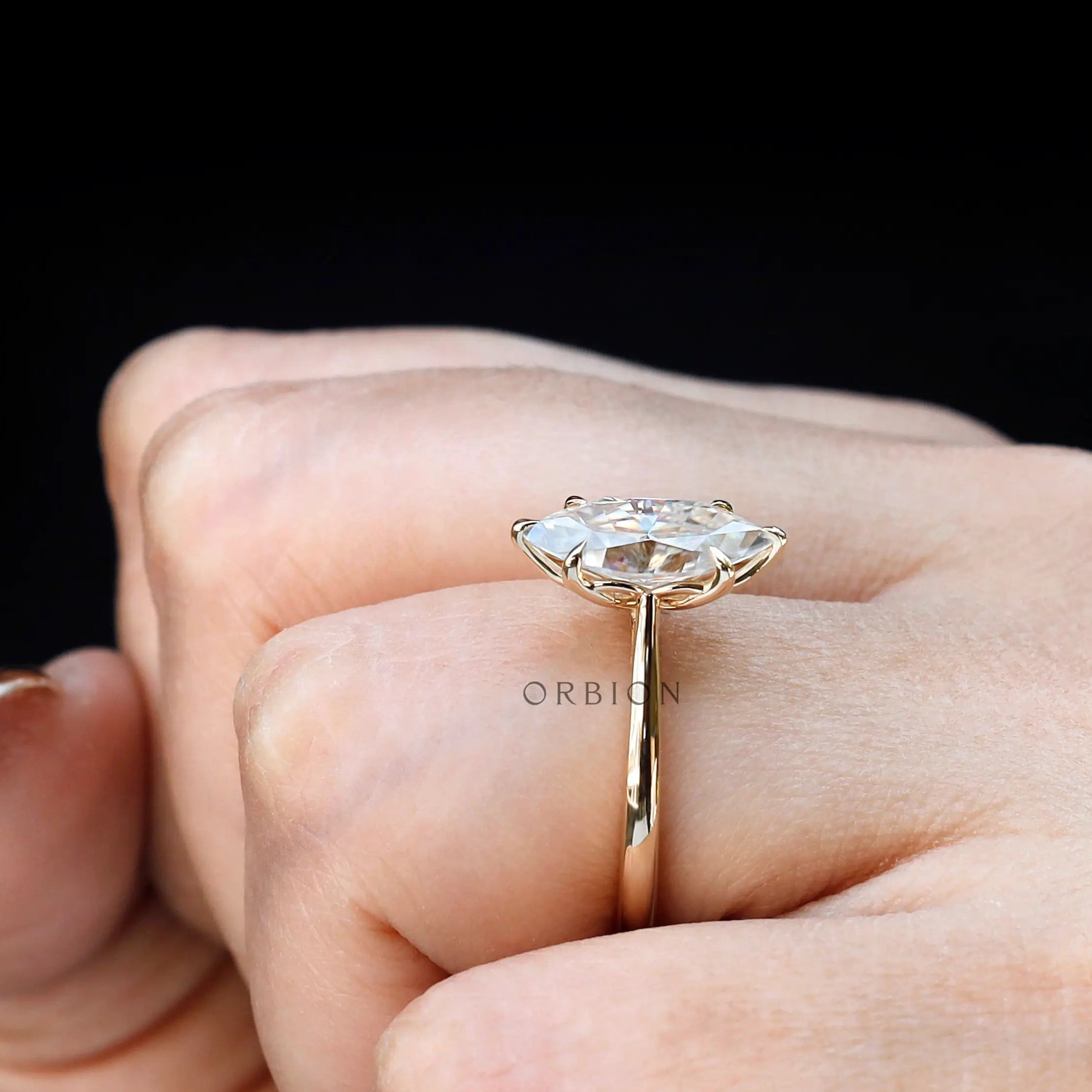 Marquise moissanite 6 prong ring on hand in yellow gold