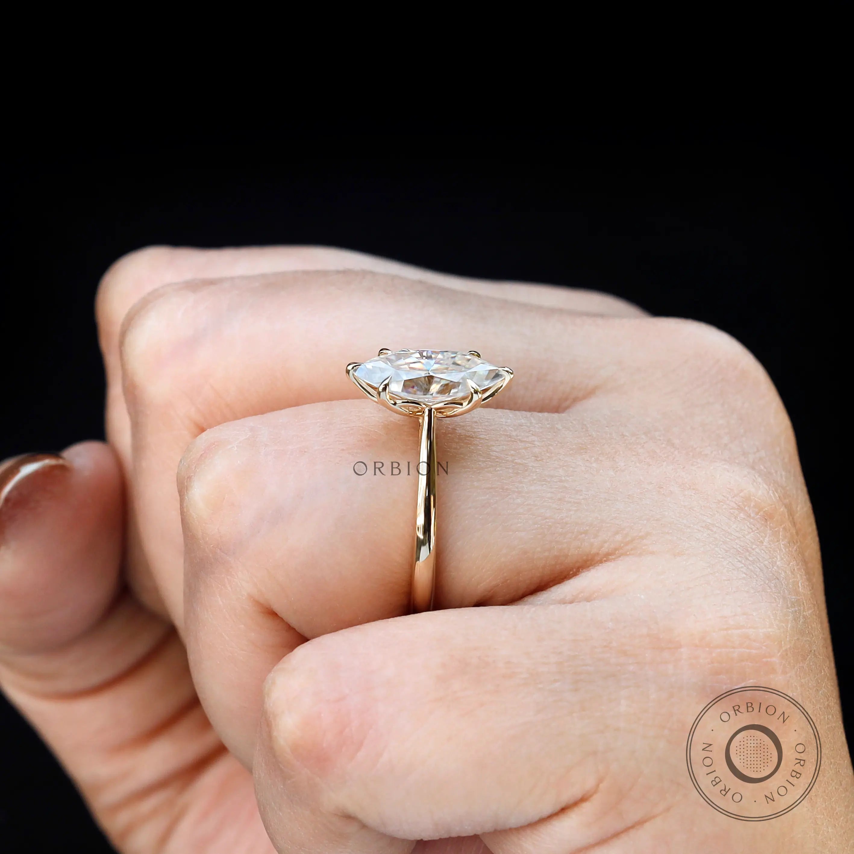 Marquise moissanite 6 prong ring on hand in yellow gold