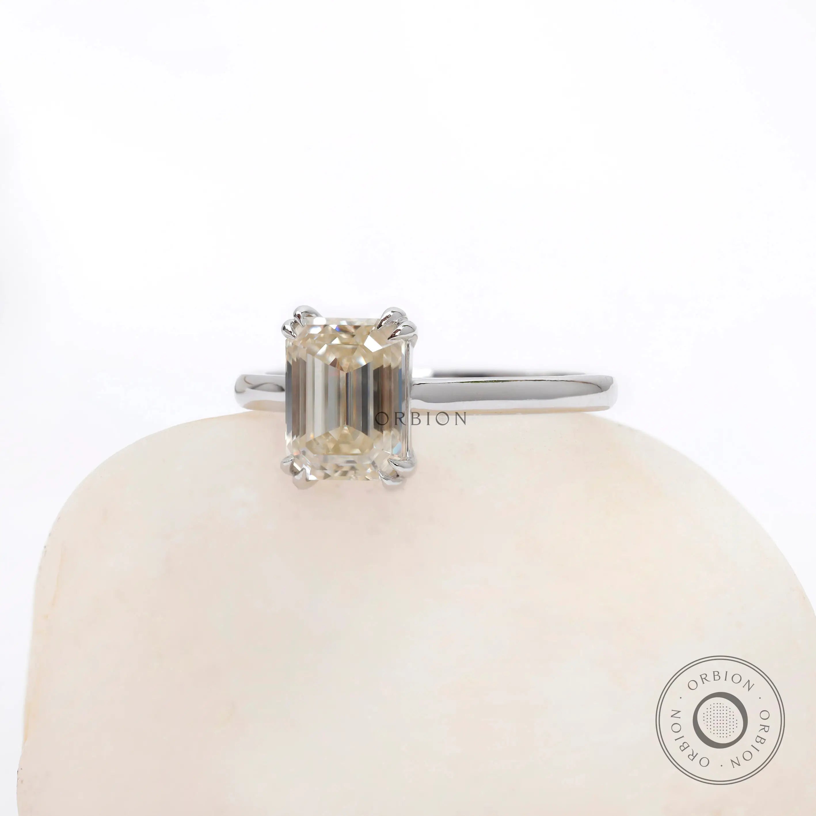 Slight angled front view showing emerald step facets and double claw prongs