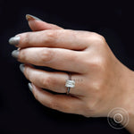 On-hand lifestyle view of emerald cut solitaire ring on black background