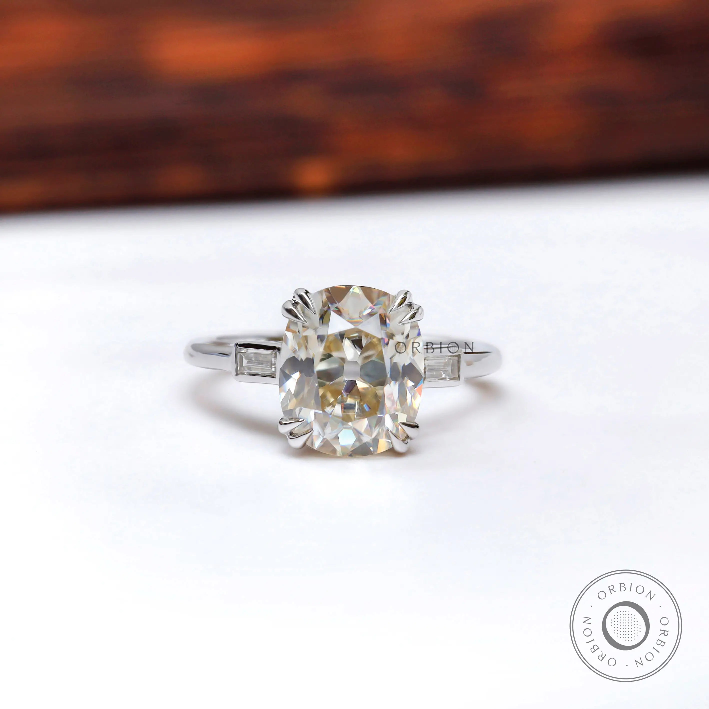 Front view of elongated cushion moissanite three stone ring in white gold.