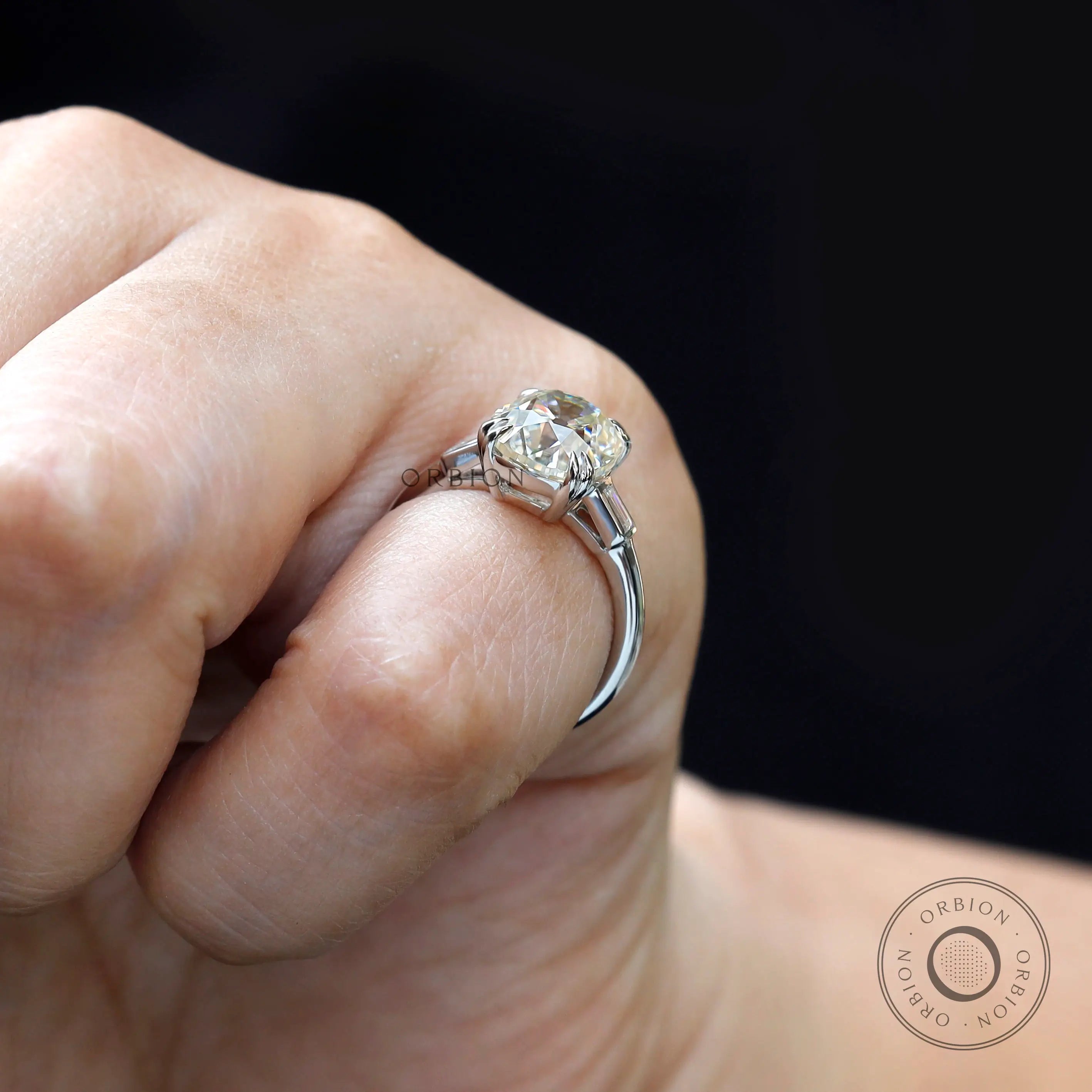 On-hand side view three-stone ring with baguette accents.