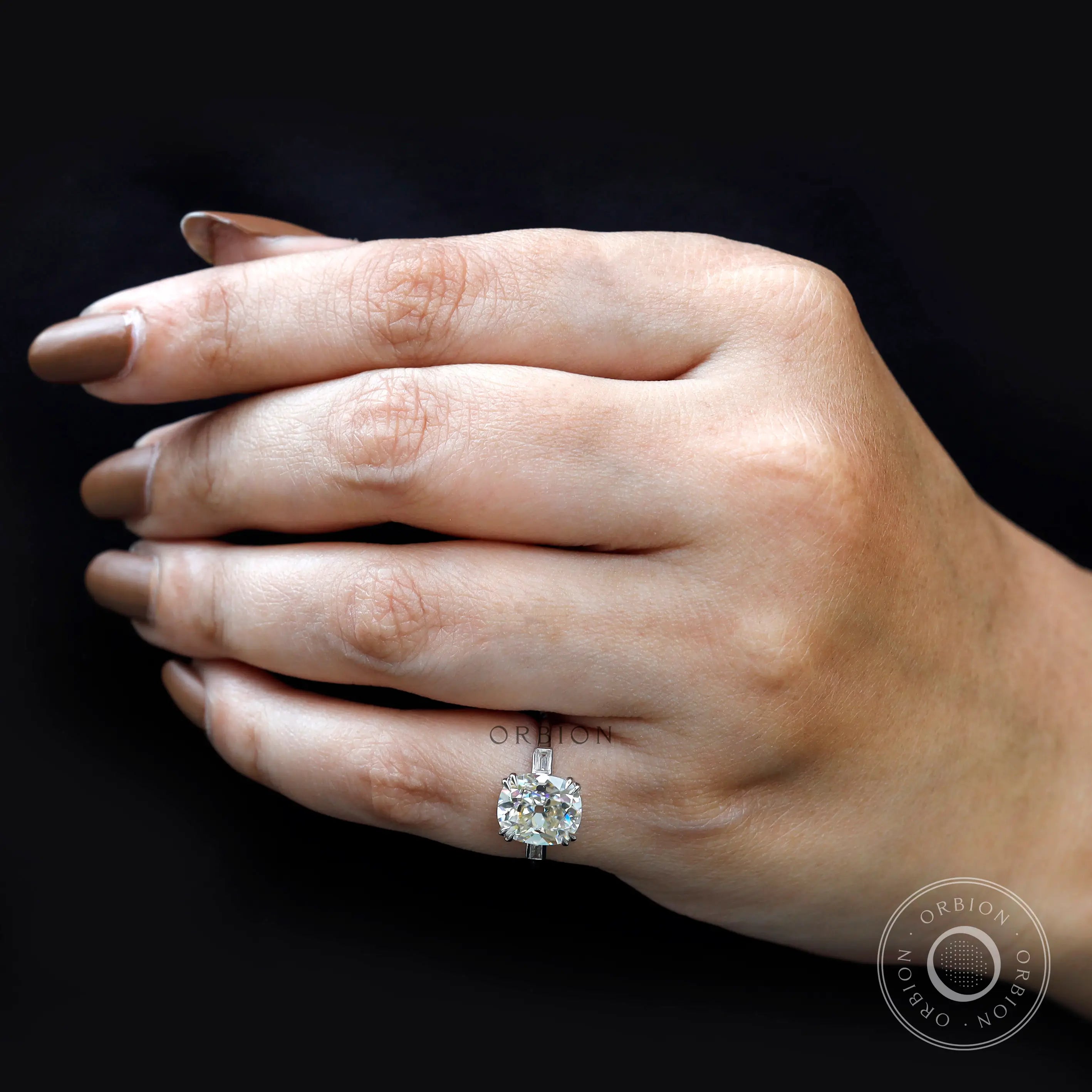 On-hand side view three-stone ring with baguette accents.