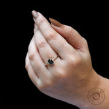 Sleek yellow gold bezel solitaire with dark moissanite stone.