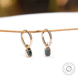 Dark green emerald cut moissanite huggie hoop drop earrings in 10K yellow gold