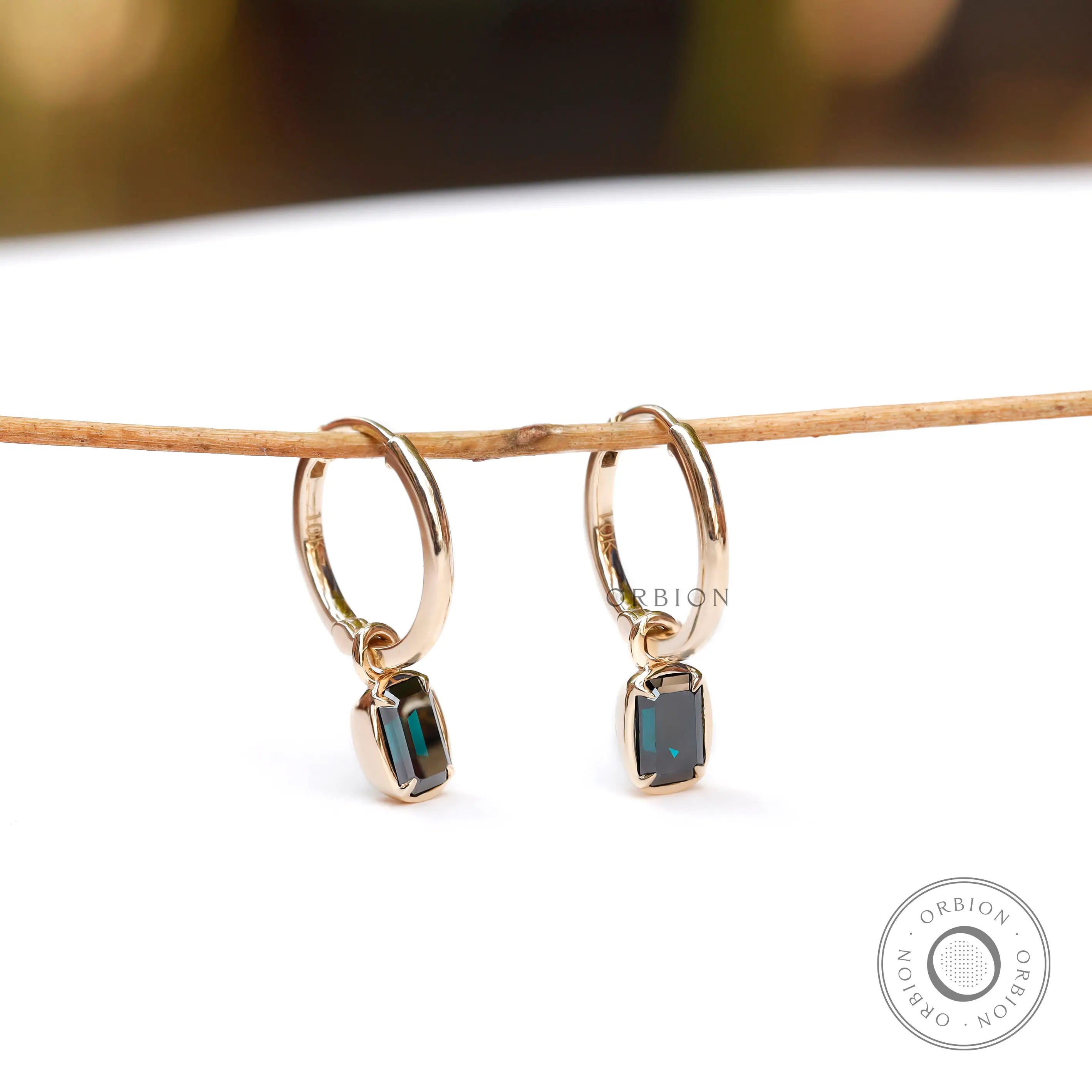 Dark green emerald cut moissanite huggie hoop drop earrings in 10K yellow gold