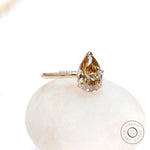 Angled front view of pear hidden halo engagement ring