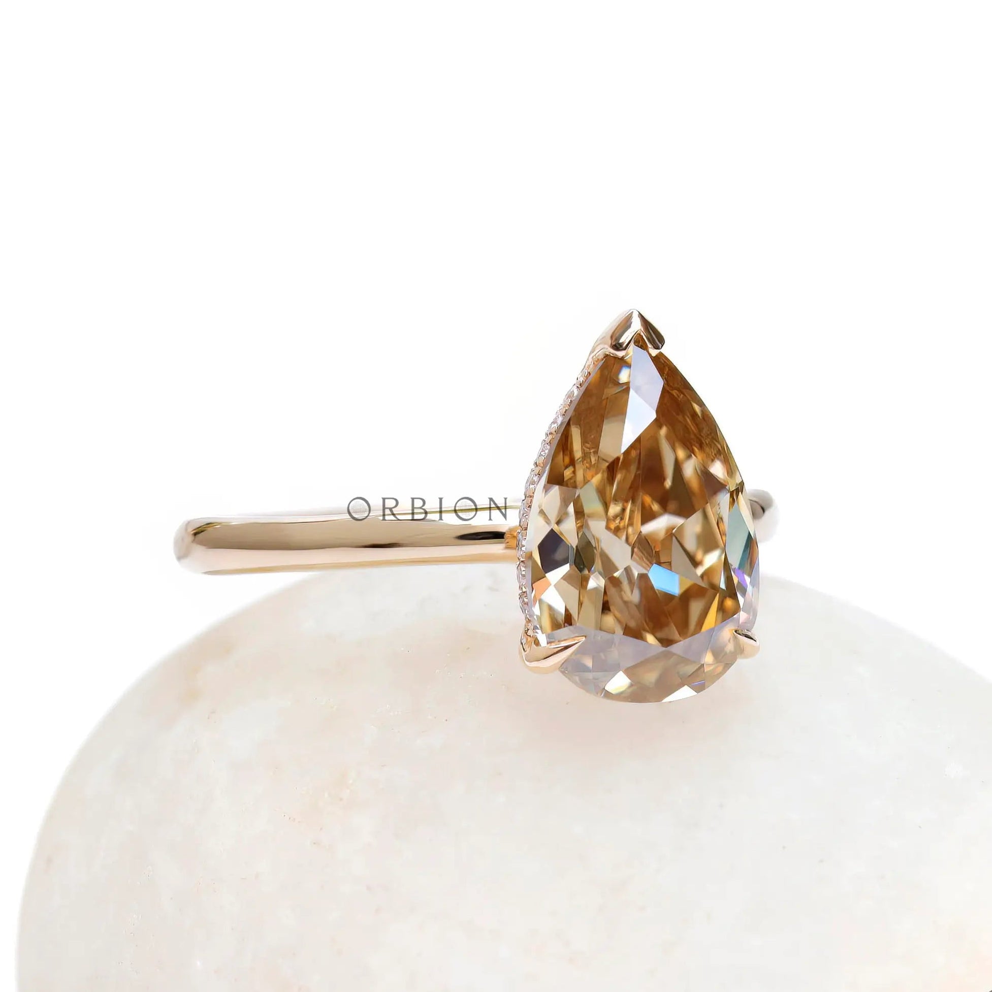 Angled front view of pear hidden halo engagement ring