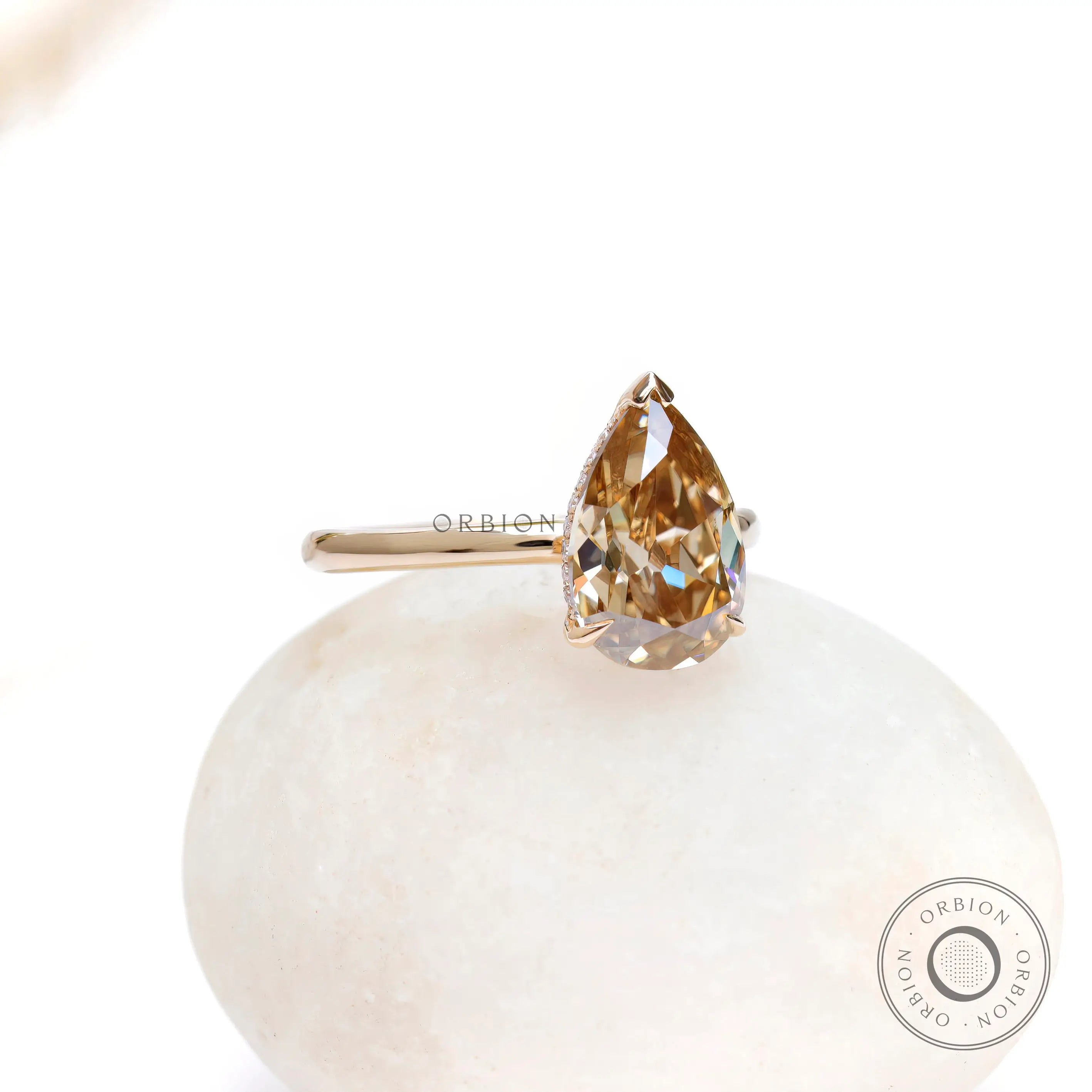 Angled front view of pear hidden halo engagement ring