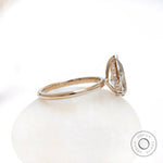 Side view of pear solitaire ring with hidden halo