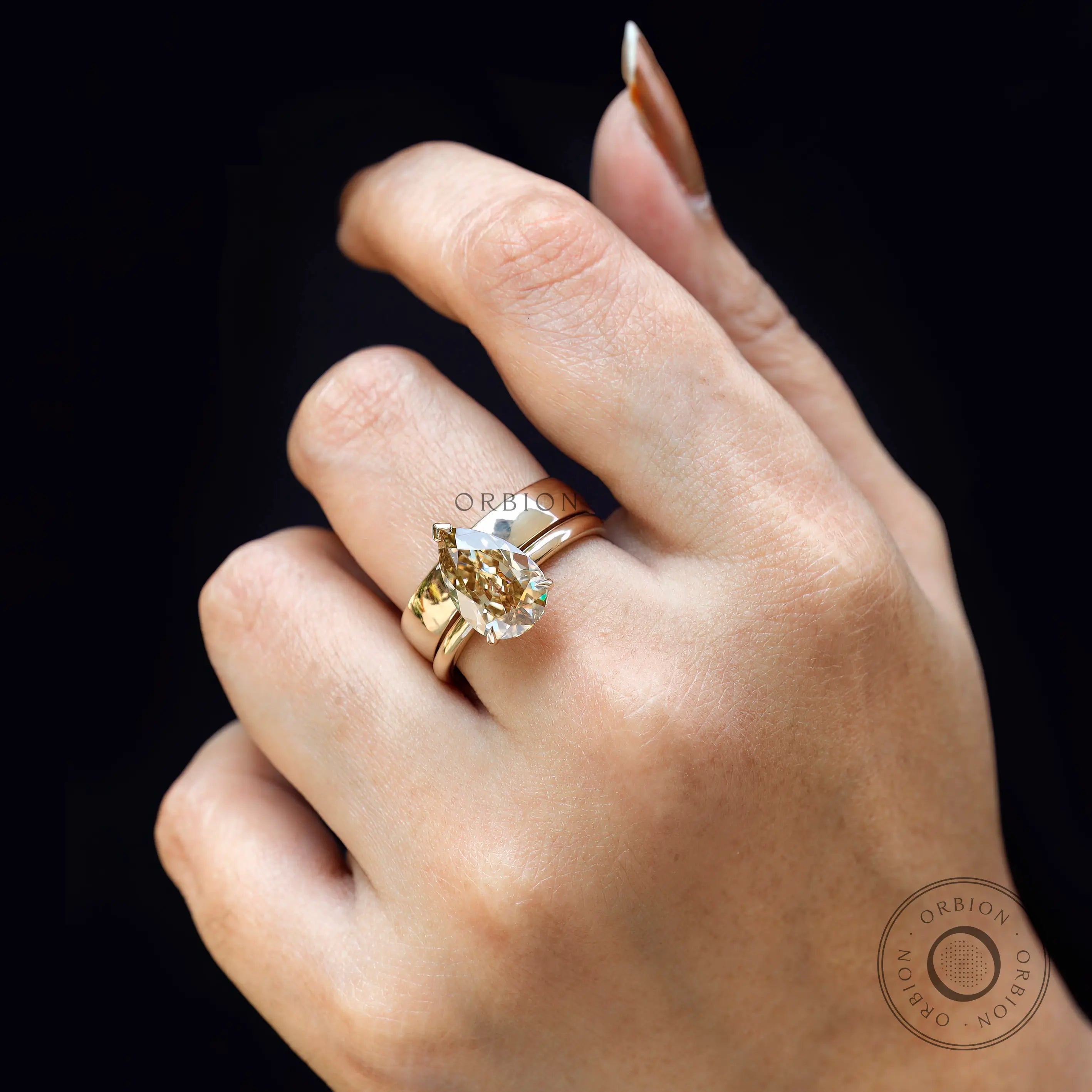Lifestyle view of pear Old Mine Cut champagne moissanite ring