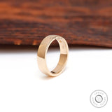 Angled standing view of plain comfort fit wedding band in high polish yellow gold.