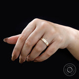 Plain yellow gold wedding band worn on hand with a clean minimalist look.