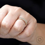 Close-up of yellow gold comfort fit wedding band on finger showing high polish shine.